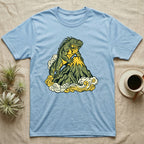 Light blue t-shirt featuring a green iguana on a mountain peak surrounded by clouds.