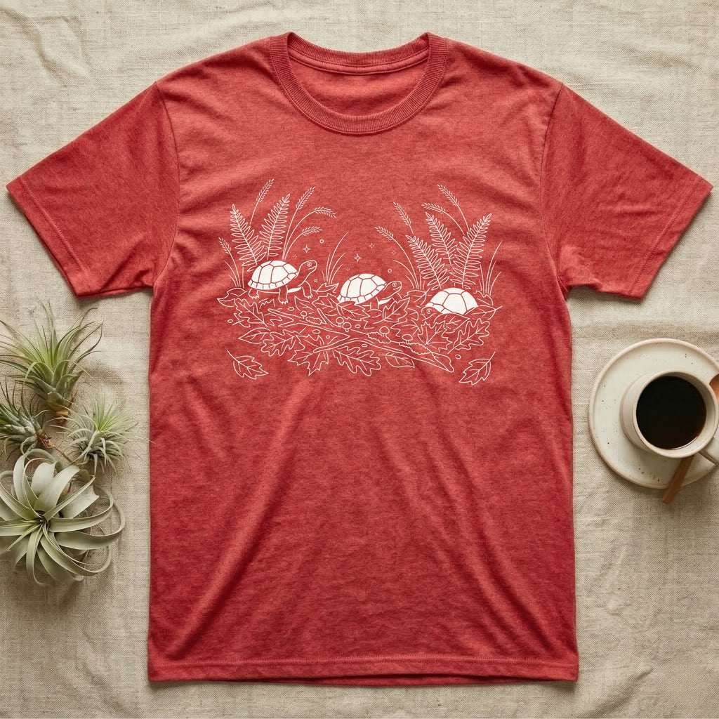 Box Turtle Botanical T-Shirt in Heather Red — Three small eastern box turtles in fine white line ringing a fanned spray of ferns, grasses and leaf litter.