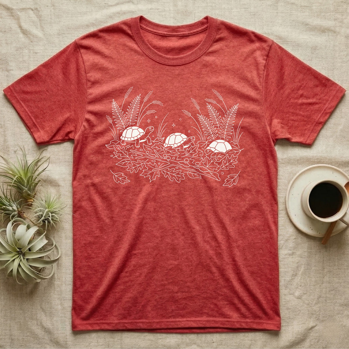 Box Turtle Botanical T-Shirt in Heather Red — Three small eastern box turtles in fine white line ringing a fanned spray of ferns, grasses and leaf litter.