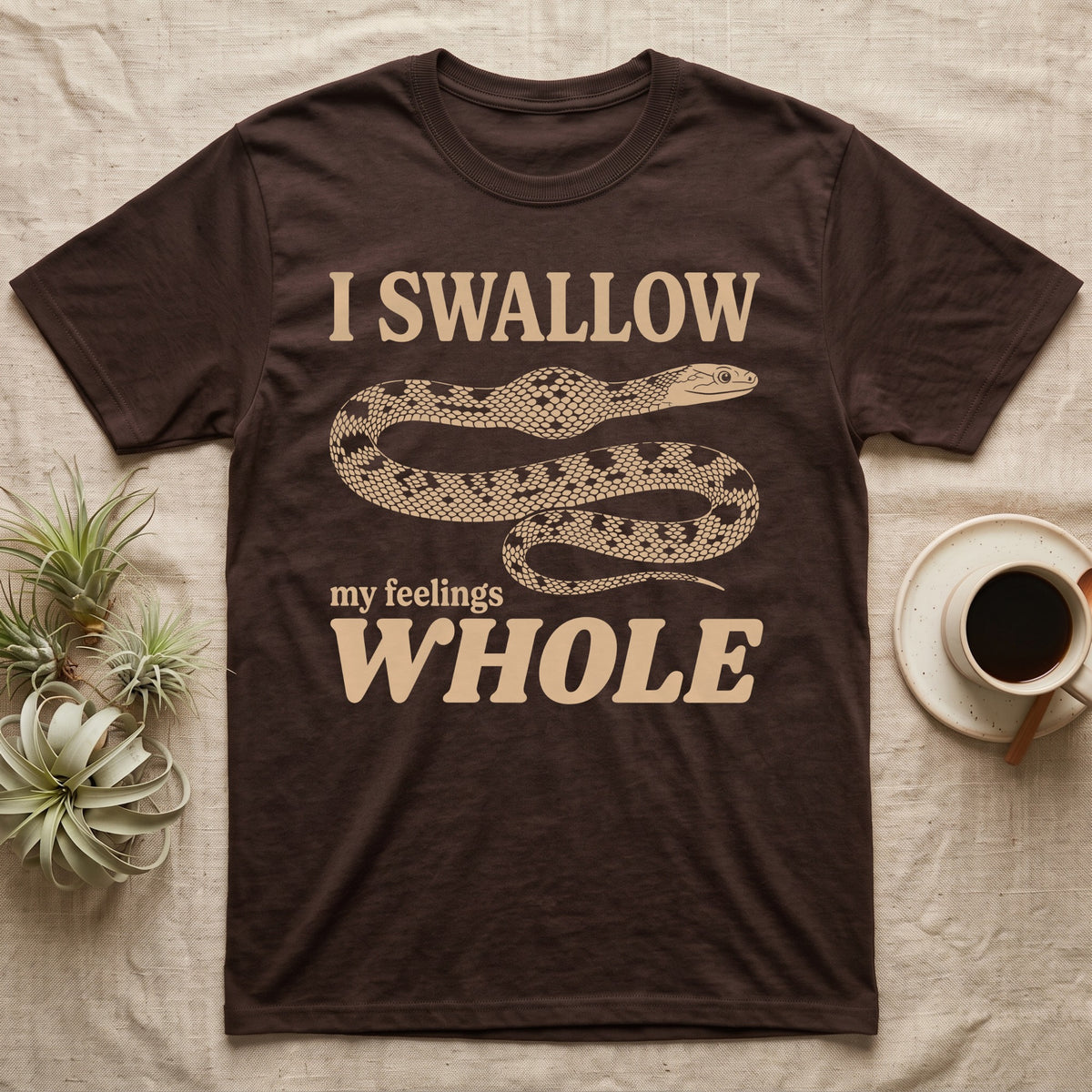 Corn Snake Lump T-Shirt in Dark Chocolate — Cream scale-mosaic corn snake on black with an oval bulge behind its neck under cream words: I SWALLOW my feelings WHOLE