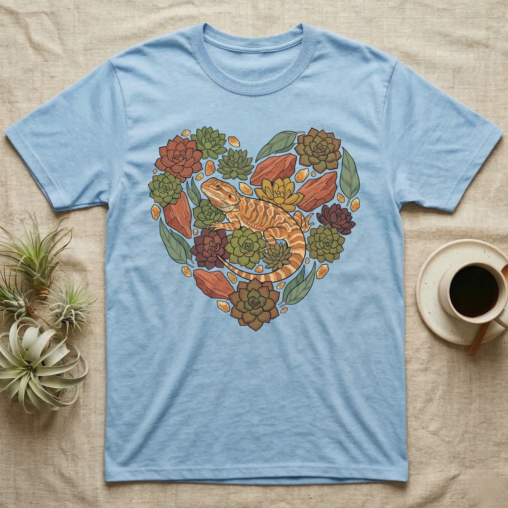 Light blue t-shirt with heart-shaped succulent and lizard graphic.