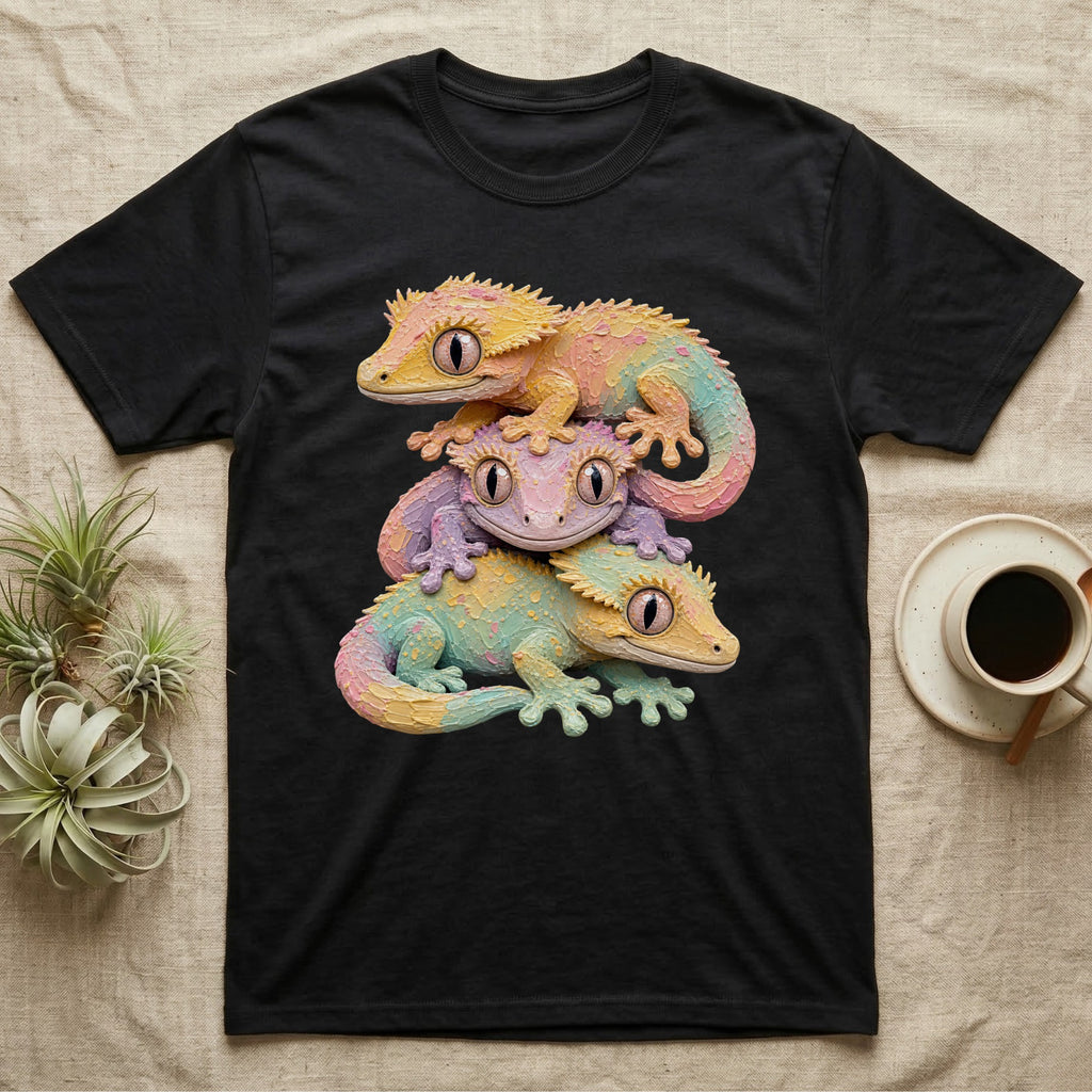 Three colorful geckos stacked on a black t-shirt.