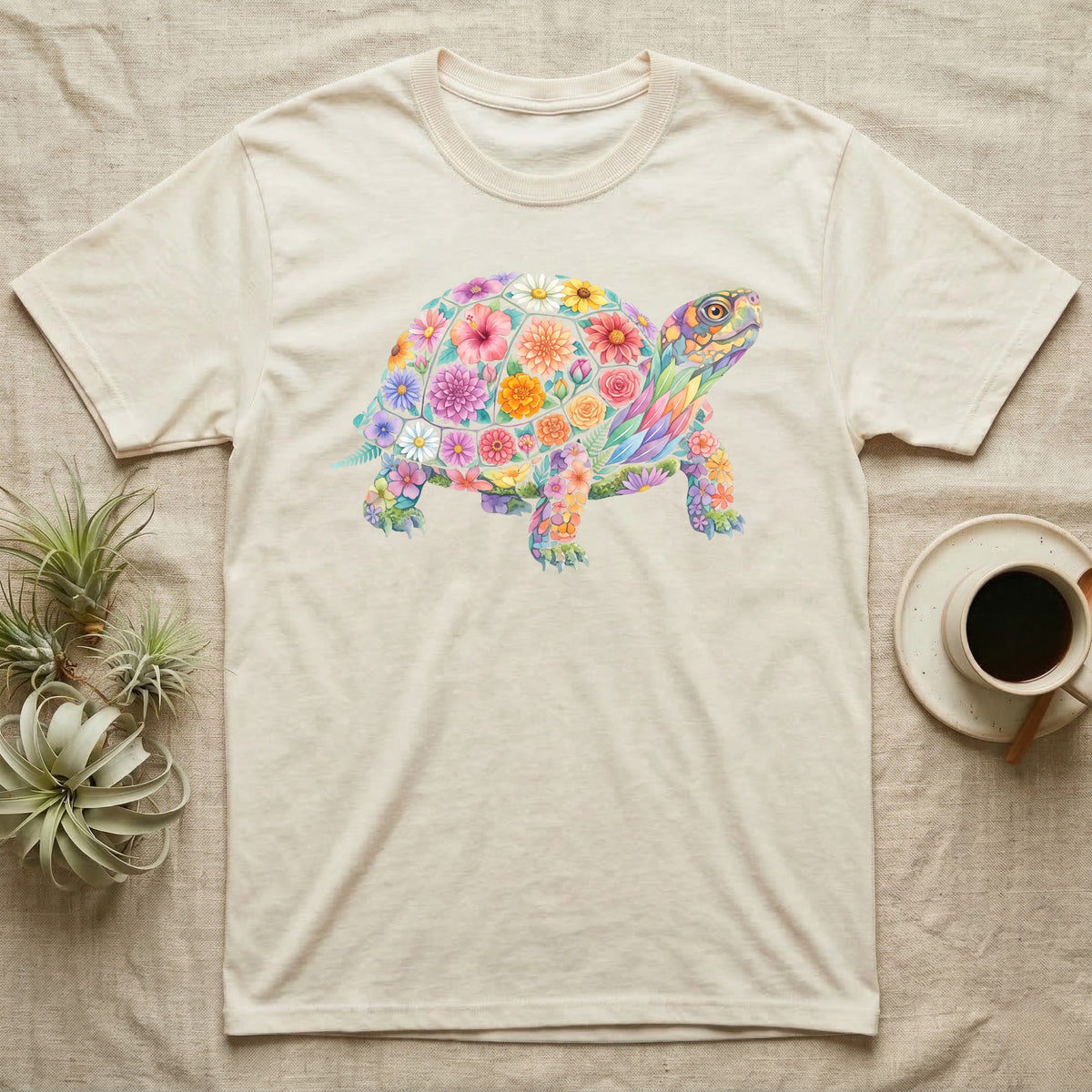 Box Turtle Mosaic T-Shirt in Natural — An eastern box turtle on a rising diagonal, its domed shell and legs built from painted watercolour flowers and leaves.