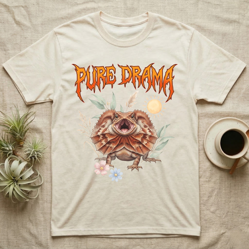 Frilled Dragon Feral T-Shirt in Natural — Frilled dragon with its neck frill flared and mouth gaping under a jagged fiery-orange metal "PURE DRAMA" wordmark.