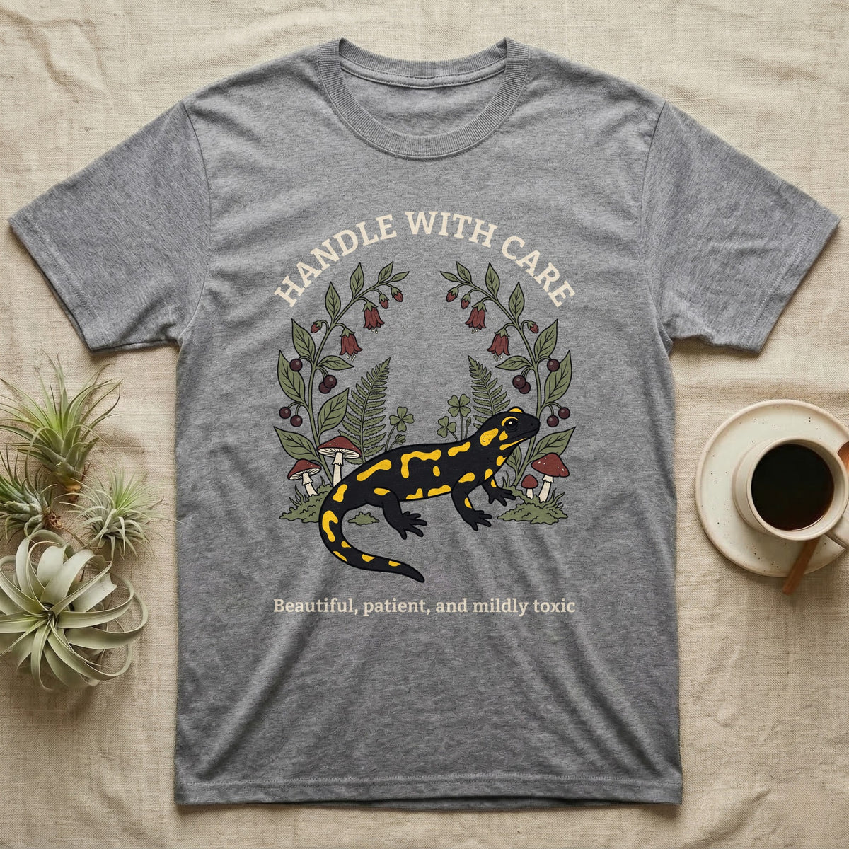 Fire Salamander Poison Plate T-Shirt in Sport Grey — Naturalist apothecary-plate illustration of a fire salamander framed by a symmetric wreath of woodland botanicals.
