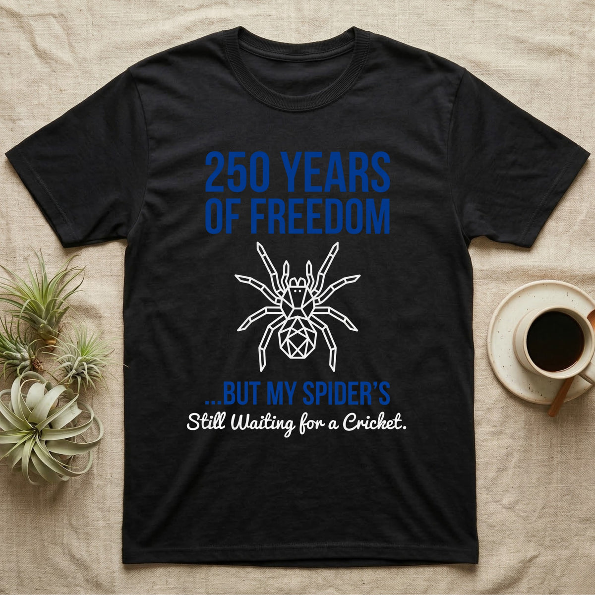 Tarantula Waiting For Cricket Tee in Black — Minimalist geometric tee with a low-poly white tarantula and blue text reading 250 Years Of Freedom but my spider's still waiting for a cricket.