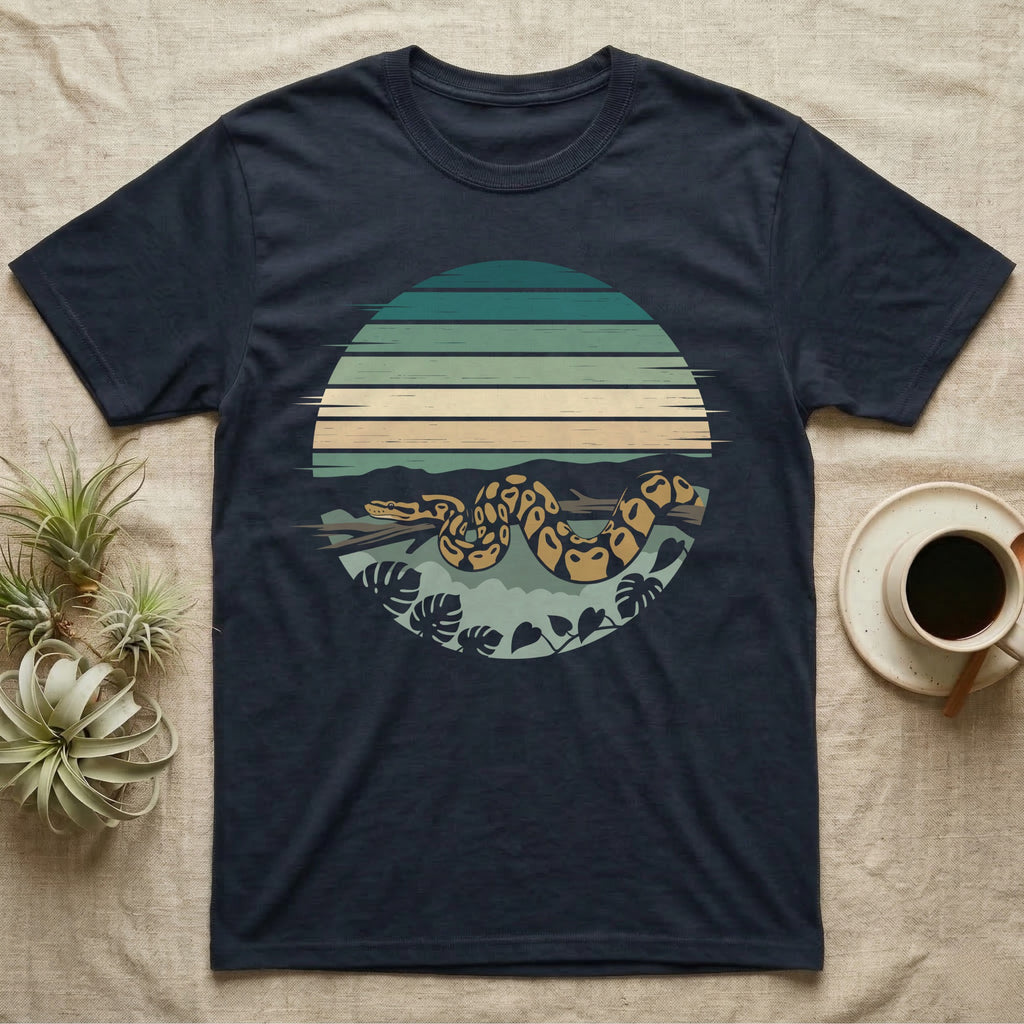 Ball Python Monstera T-Shirt in Navy — Ball python coiled through a striped rainforest circle window with monstera and pothos on a near-black tee