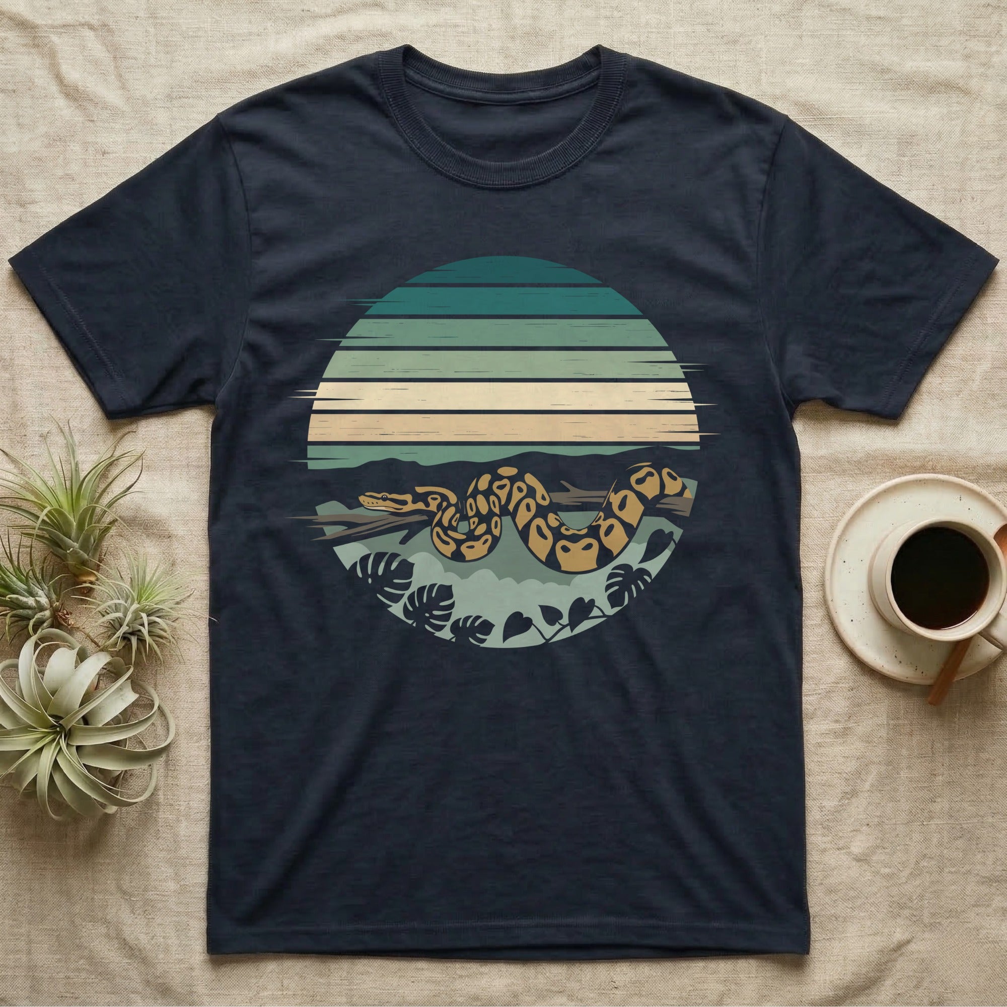 Ball Python Monstera T-Shirt in Navy — Ball python coiled through a striped rainforest circle window with monstera and pothos on a near-black tee