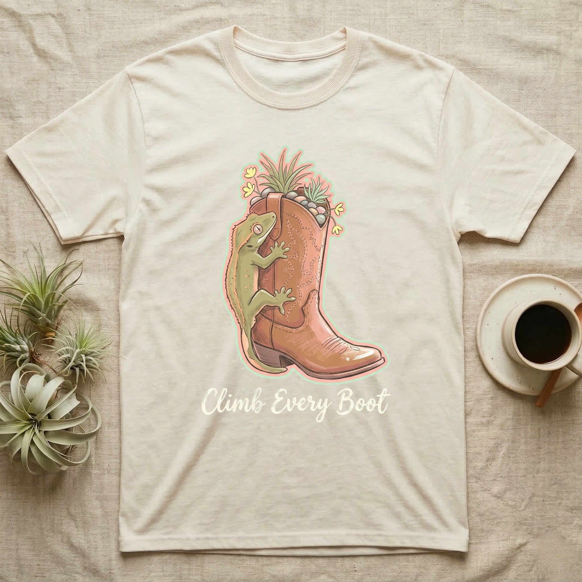 Cowboy boot with lizard and plants, "Climb Every Boot" text.