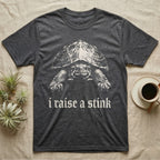 Musk Turtle Stink T-Shirt in Dark Heather — Photo of a small musk turtle facing forward above the blackletter line i raise a stink