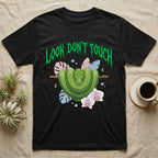 Green Tree Python Feral T-Shirt in Black — Green tree python in a saddle coil on a branch under a jagged emerald metal "LOOK DON'T TOUCH" wordmark and orchids.