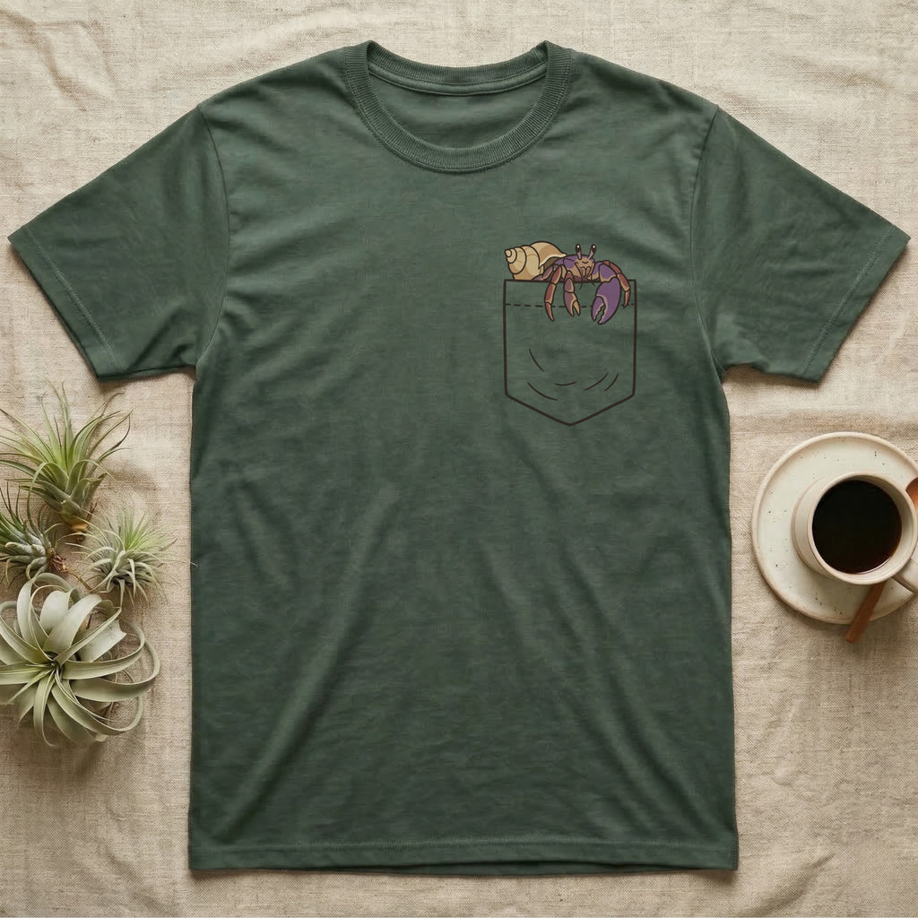 Hermit Crab Pocket T-Shirt in Military Green — Cartoon purple pincher hermit crab peeking out of a chest pocket, its empty shell on the pocket edge