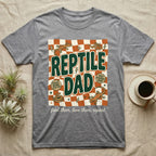 Gray t-shirt with "Reptile Dad" graphic, featuring lizards and checkered pattern.