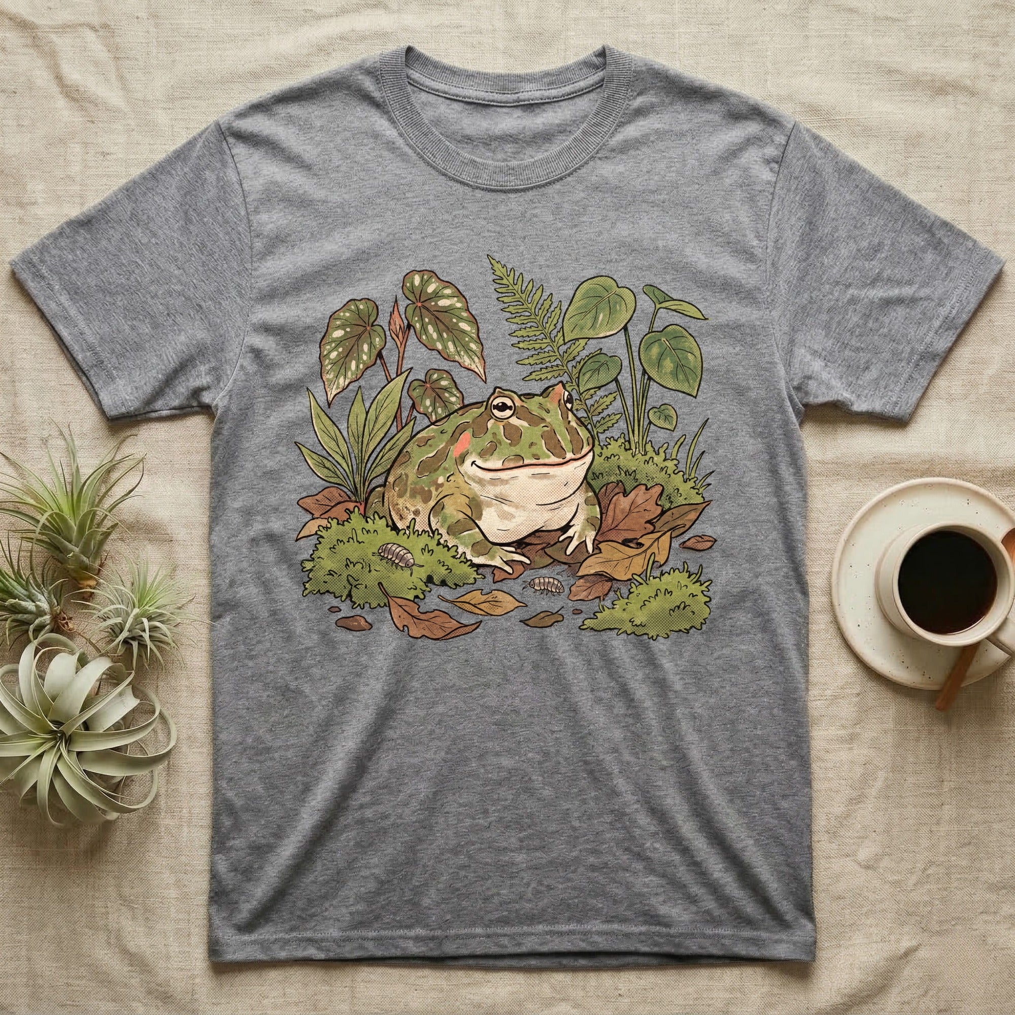 Bioactive Pacman Frog T-Shirt in Sport Grey — Warm botanical illustration of a content pacman frog half-buried in a lush bioactive habitat of moss and leaf litter.