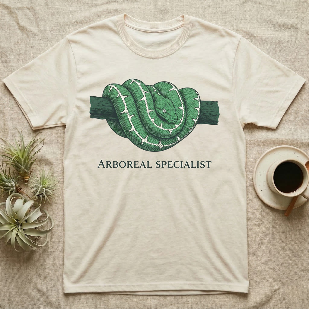 Green snake coiled on a branch, "Arboreal Specialist" text on cream t-shirt.