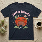 Tomato Frog Softie T-Shirt in Navy — Round red-orange tomato frog facing forward under a puffy pastel "just a tomato" bubble wordmark with tiny hearts.