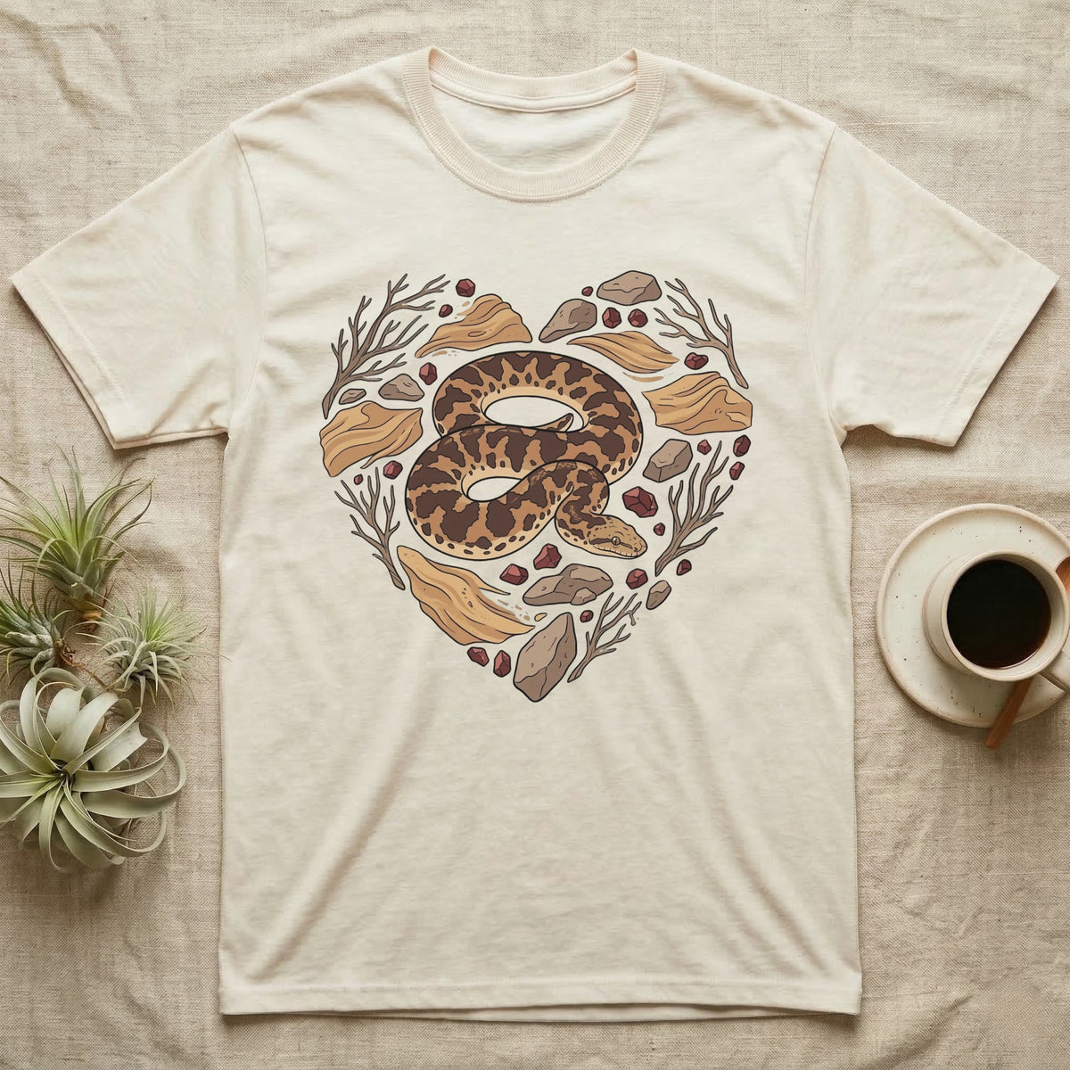 Cream t-shirt with a heart-shaped design of a coiled snake and natural elements.