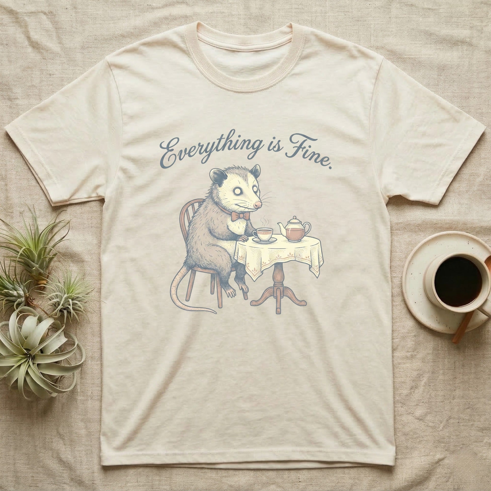 T-shirt with illustration of a possum sitting at a table with tea, "Everything is Fine" text.