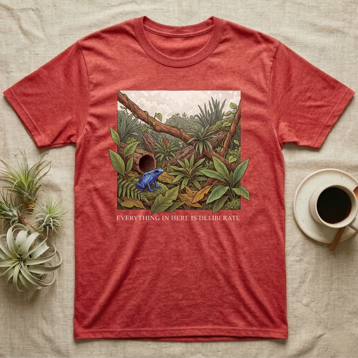Dart Frog Bioactive Vivarium T-Shirt in Heather Red — Illustrated panel of a cobalt dart frog in a layered planted vivarium, leaves crossing the inked border.