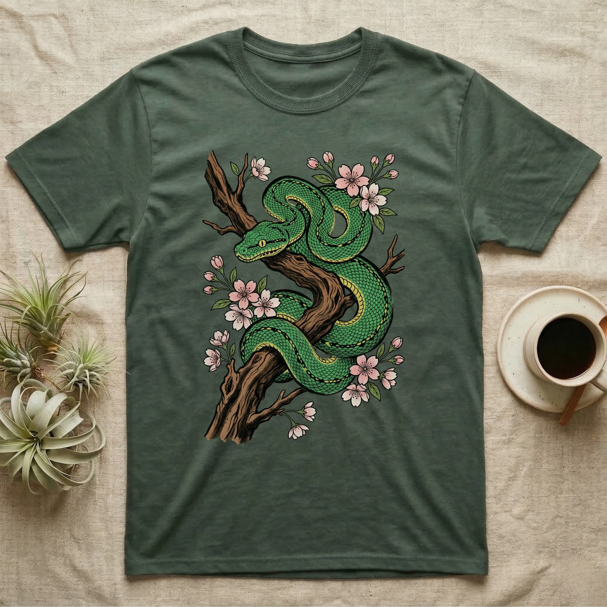 Green snake coiled on a tree branch with pink cherry blossoms.
