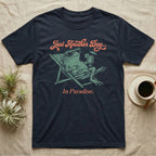 Fire-Bellied Toad Paradise T-Shirt in Navy — Illustrated fire-bellied toad reclining in a beach chair with sunglasses and a cocktail, coral script reading Just Another Day In Paradise.