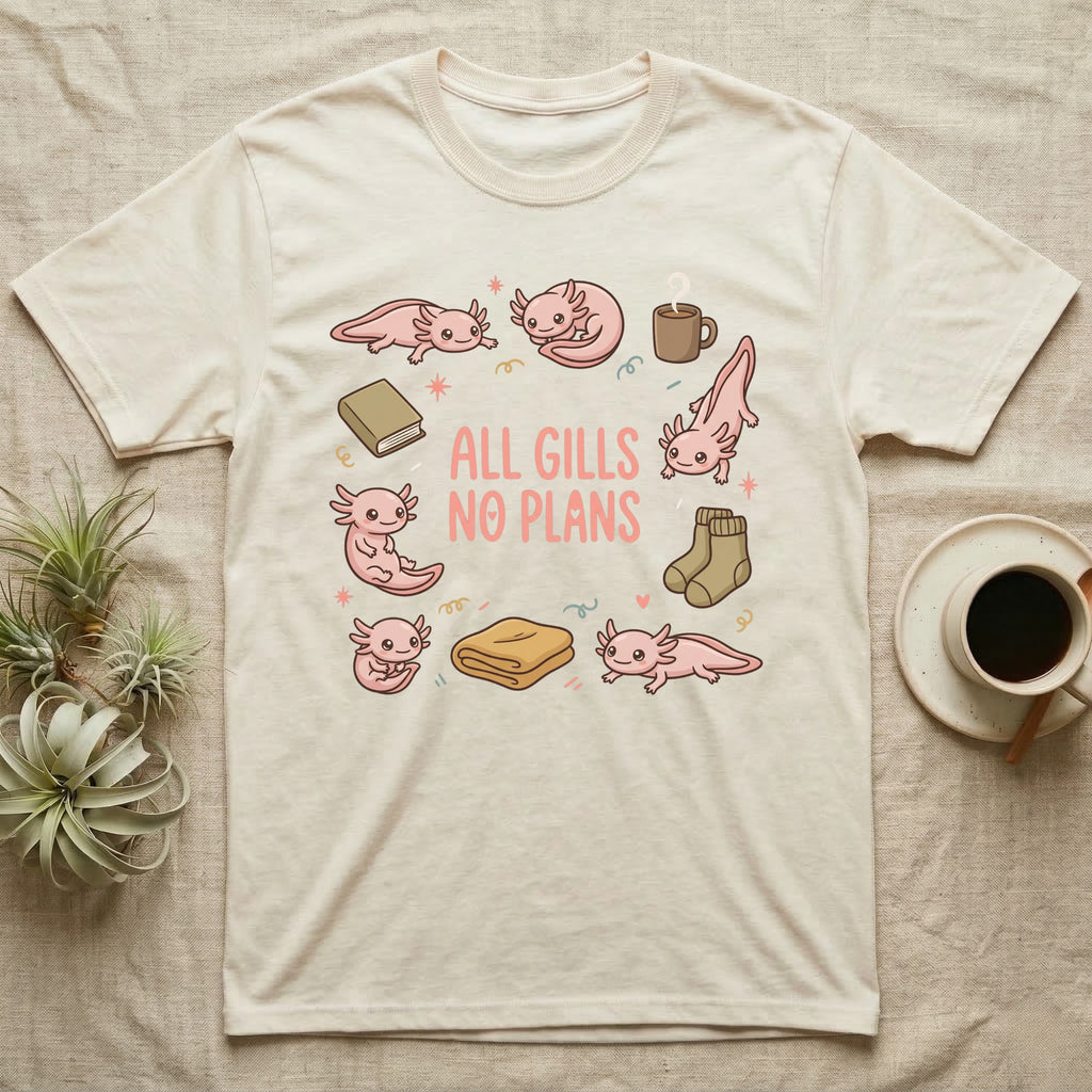 Axolotl All Gills No Plans T-Shirt in Natural — Cartoon sticker collection of six leucistic axolotls resting among a mug, socks, a blanket and a book, under the words ALL GILLS NO PLANS.