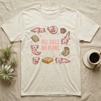 Axolotl All Gills No Plans T-Shirt in Natural — Cartoon sticker collection of six leucistic axolotls resting among a mug, socks, a blanket and a book, under the words ALL GILLS NO PLANS.