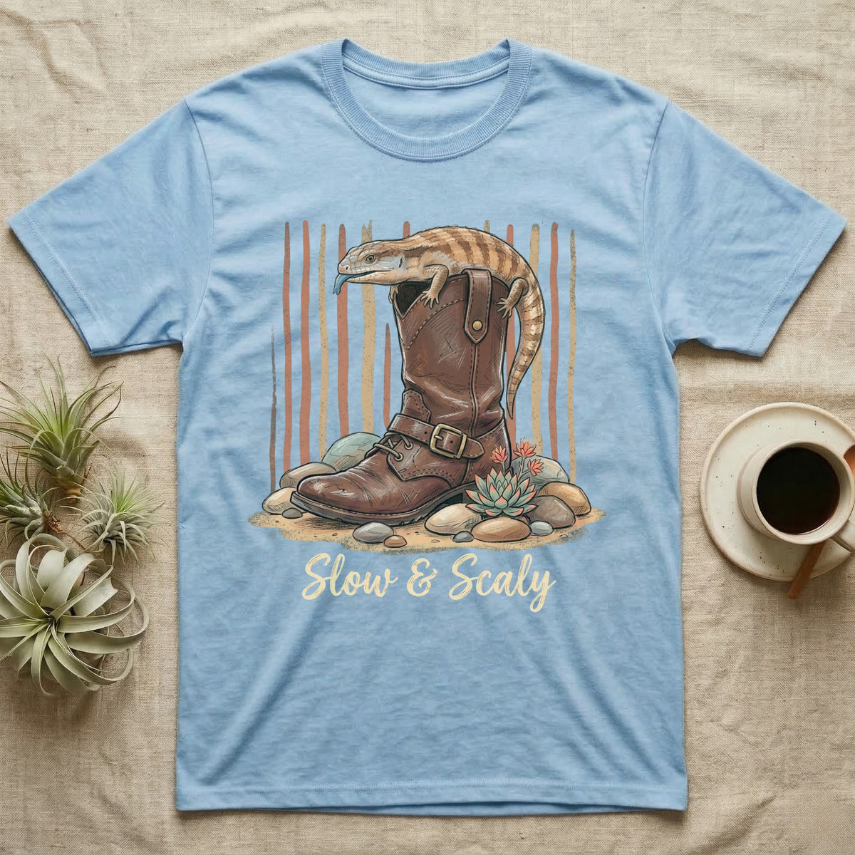 Light blue t-shirt with a lizard on a boot, "Slow & Scaly" text.