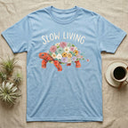 Red-Foot Tortoise Slow Living T-Shirt in Light Blue — Flat watercolour mosaic of a red-foot tortoise built entirely from terrarium flowers and ferns.