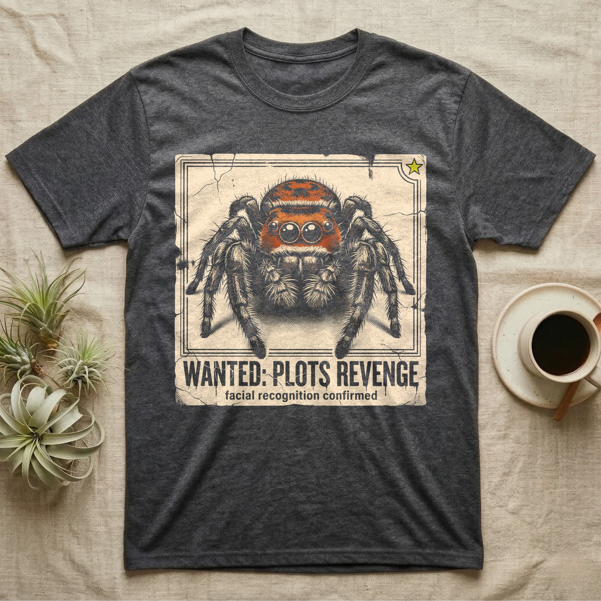 Jumping Spider Wanted T-Shirt in Dark Heather — Distressed wanted-poster illustration of a front-facing jumping spider with the banner text plots revenge below.