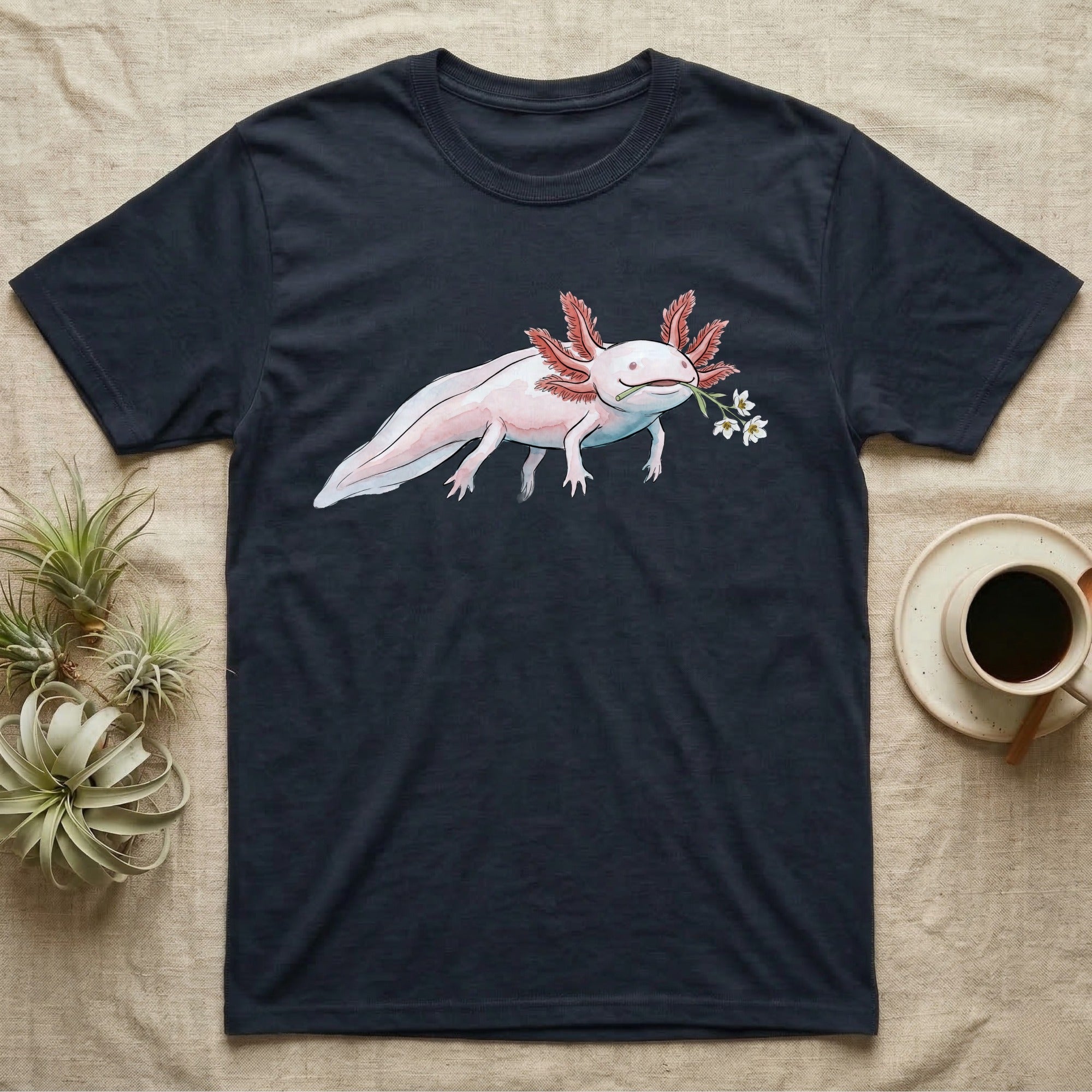 Axolotl Blossom T-Shirt in Navy — Watercolor illustration of a pink leucistic axolotl with feathery gills holding an aquatic blossom sprig, on a dark grey t-shirt.