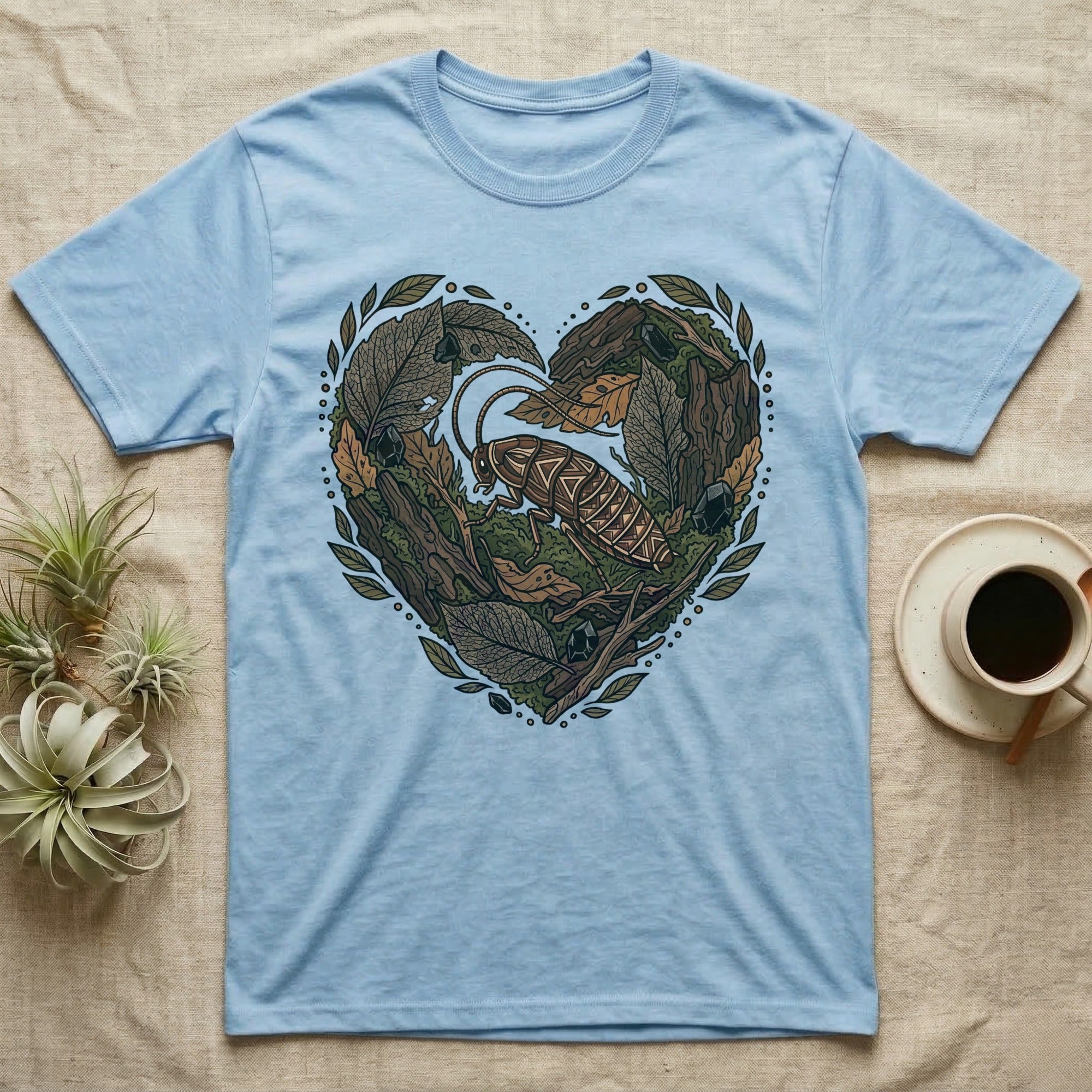 Light blue t-shirt with a heart-shaped design of leaves, wood, and a cockroach.