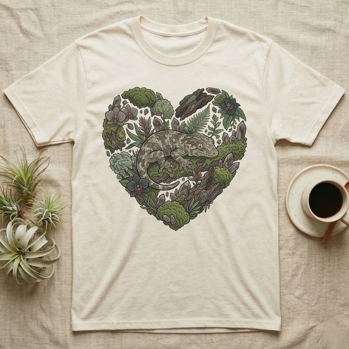 Cream t-shirt with a heart-shaped illustration of a gecko and natural elements.