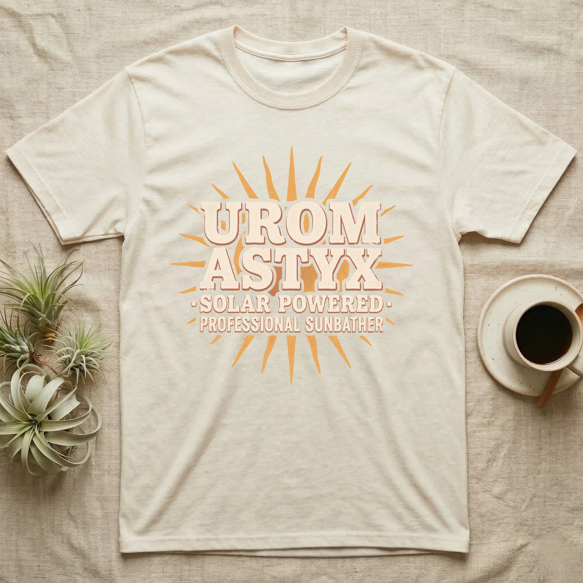 Solar Powered Uromastyx T-Shirt in Natural — Desert-poster wordmark reading "Uromastyx Solar Powered Professional Sunbather" with a small radiating sun motif.