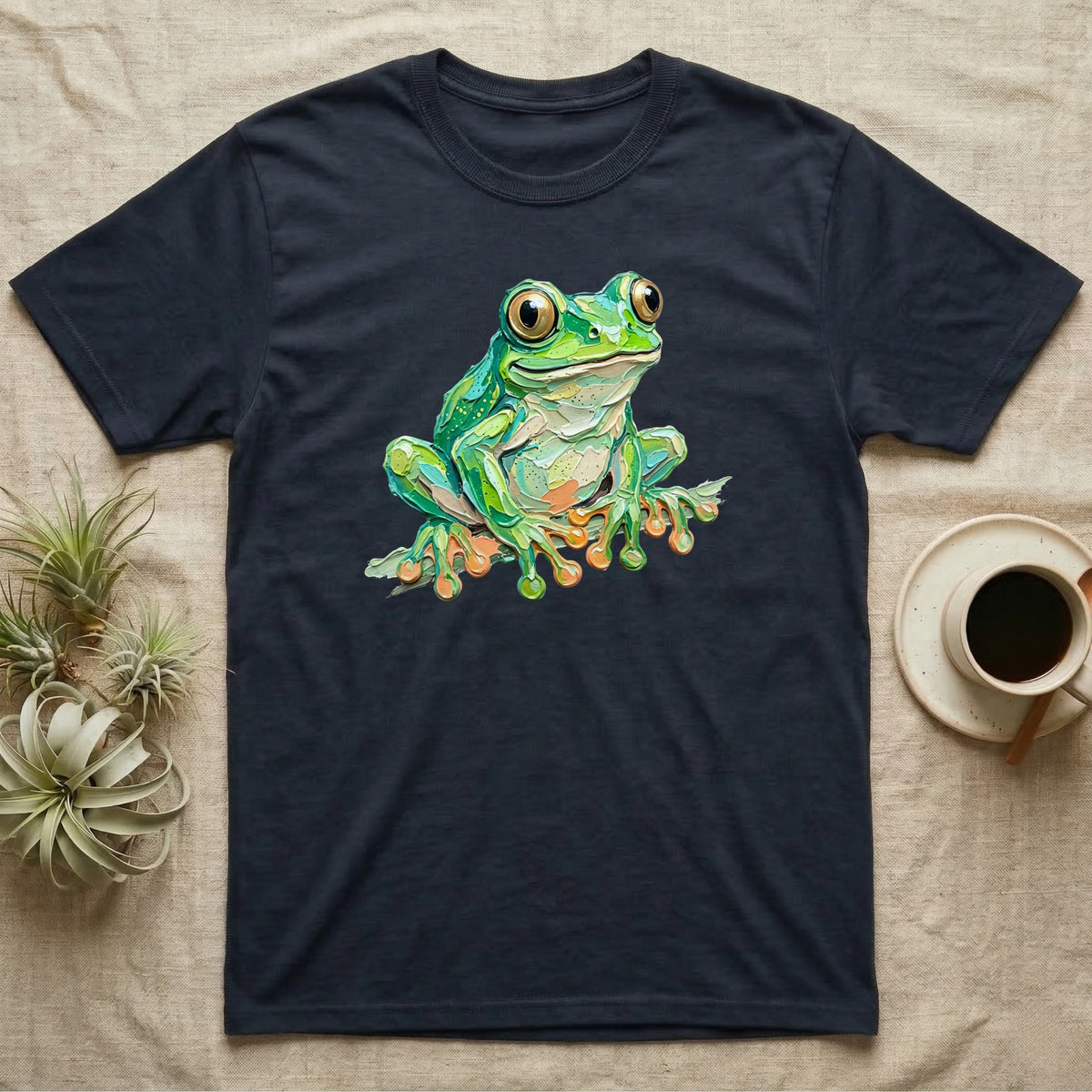 Green frog illustration on a dark navy t-shirt.