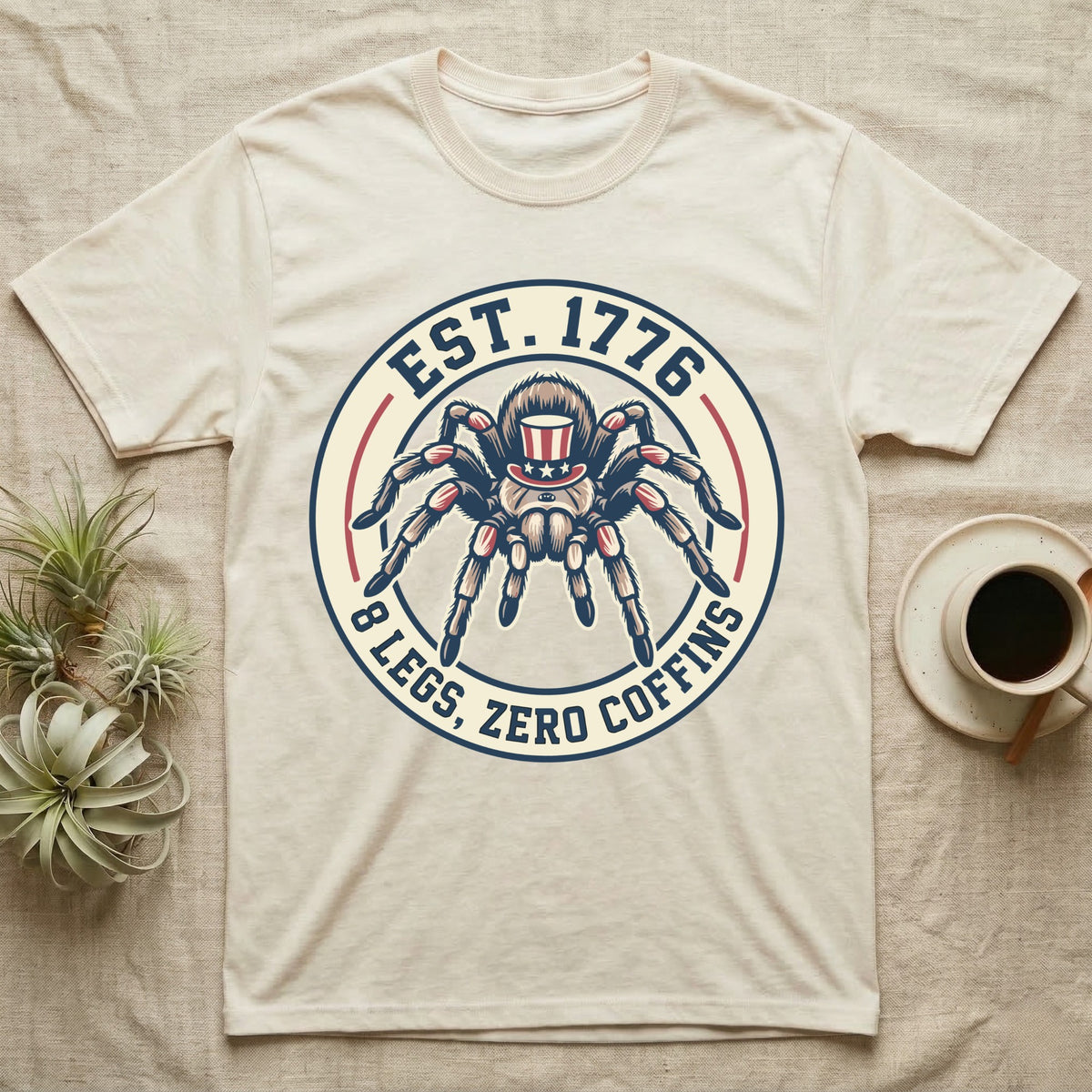 Tarantula Zero Coffins T-Shirt in Natural — Circular patch emblem of a tarantula in a top hat with arched text Est. 1776 and 8 Legs Zero Coffins.