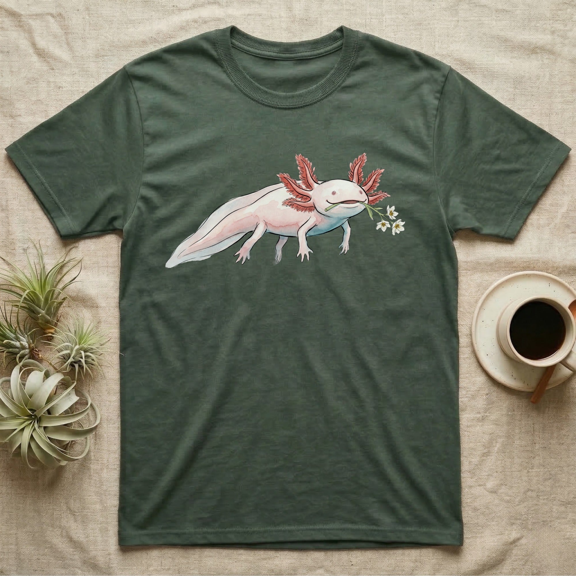 Axolotl Blossom T-Shirt in Military Green — Watercolor illustration of a pink leucistic axolotl with feathery gills holding an aquatic blossom sprig, on a dark grey t-shirt.