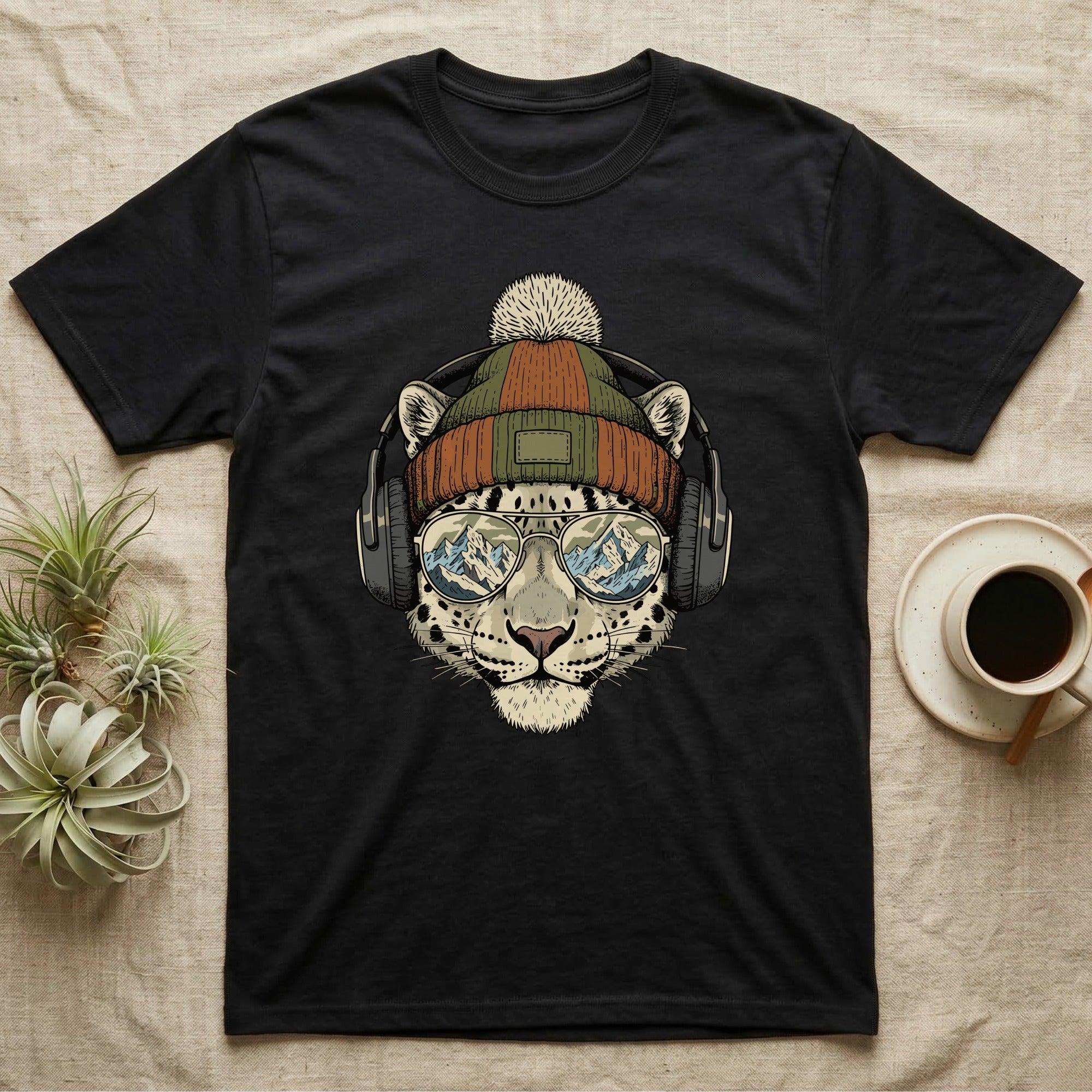 Black t-shirt featuring a leopard wearing a beanie and sunglasses with mountains reflected in the lenses.