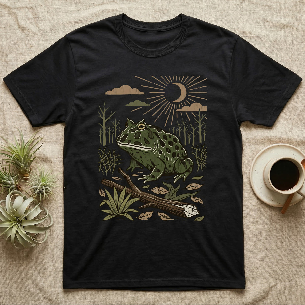 Pacman Frog Home Range T-Shirt in Black — Woodcut-style illustration of a pacman frog sitting on the Chaco forest floor among fallen branches and thorn scrub, no on-shirt text.