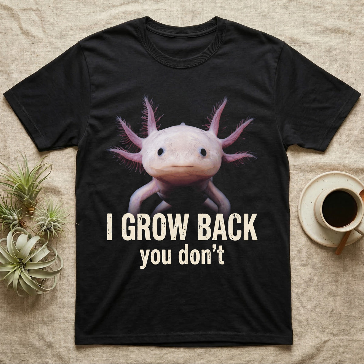 Photographic mugshot of an axolotl with gill stalks fanned wide above the hook I Grow Back, you don't. — shown on a Black tee.