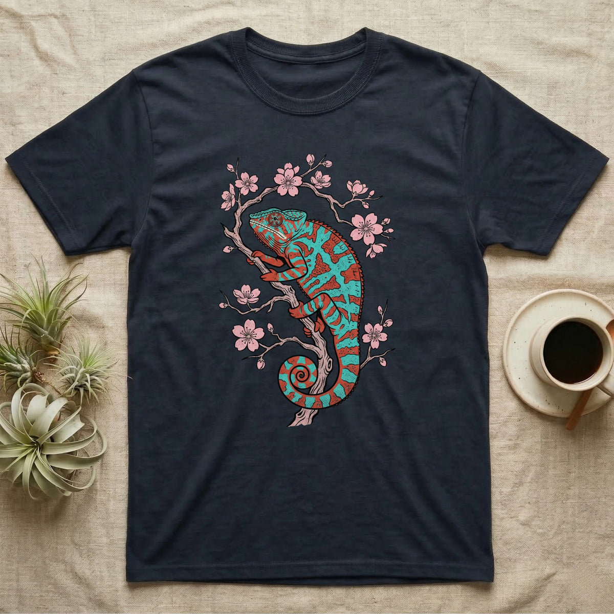 Dark t-shirt with a teal and pink chameleon on a blooming branch.