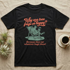Green Tree Frog Sun Chair T-Shirt in Black — Illustrated green tree frog reclining on a beach chair with sunglasses and a cocktail, coral script asking why tree frogs are so happy because they eat whatever bugs them.