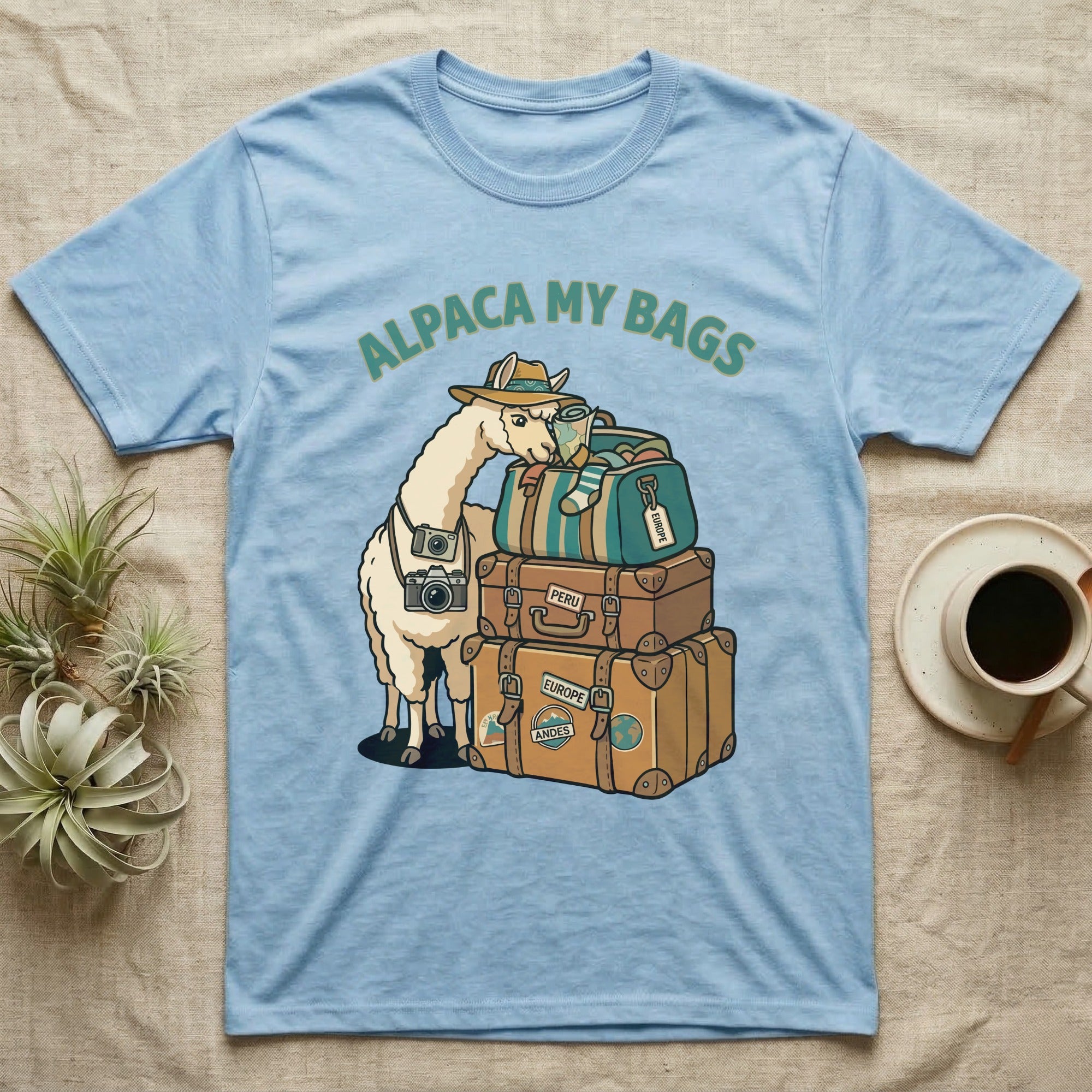 Light blue t-shirt with alpaca wearing a hat and packing luggage.