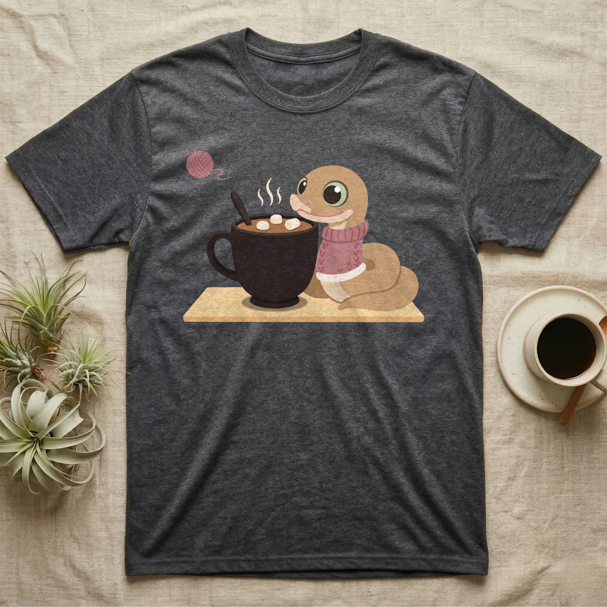 Hognose Snake Knitted Sweater T-Shirt in Dark Heather — Soft-painted illustration of a hognose snake in a knitted jumper resting beside a mug of cocoa with marshmallows.