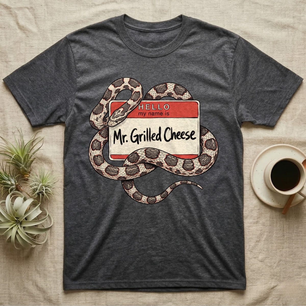 Grilled Cheese Corn Snake T-Shirt in Dark Heather — Flat retro illustration of a corn snake coiled through a "Hello my name is Mr. Grilled Cheese" name-tag badge.