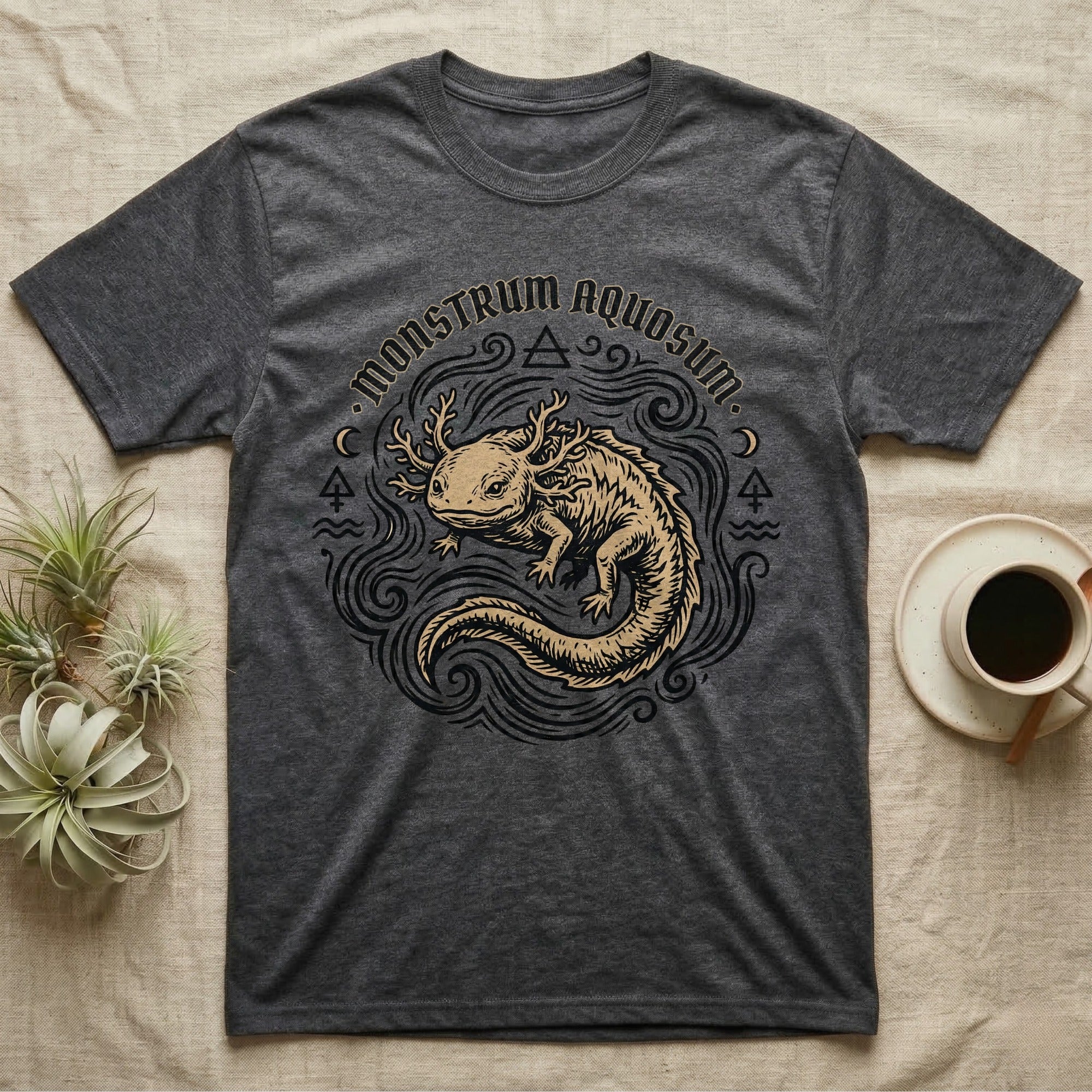 Dark gray t-shirt with golden axolotl illustration and "Monstrum Aquosum" text.