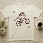 Tree Frog Can-Can T-Shirt in Natural — Distressed one-ink oxblood screenprint of a White's tree frog airborne on a BMX bike, both back legs kicked off the pedals and swung to one side, hands still on the bars.