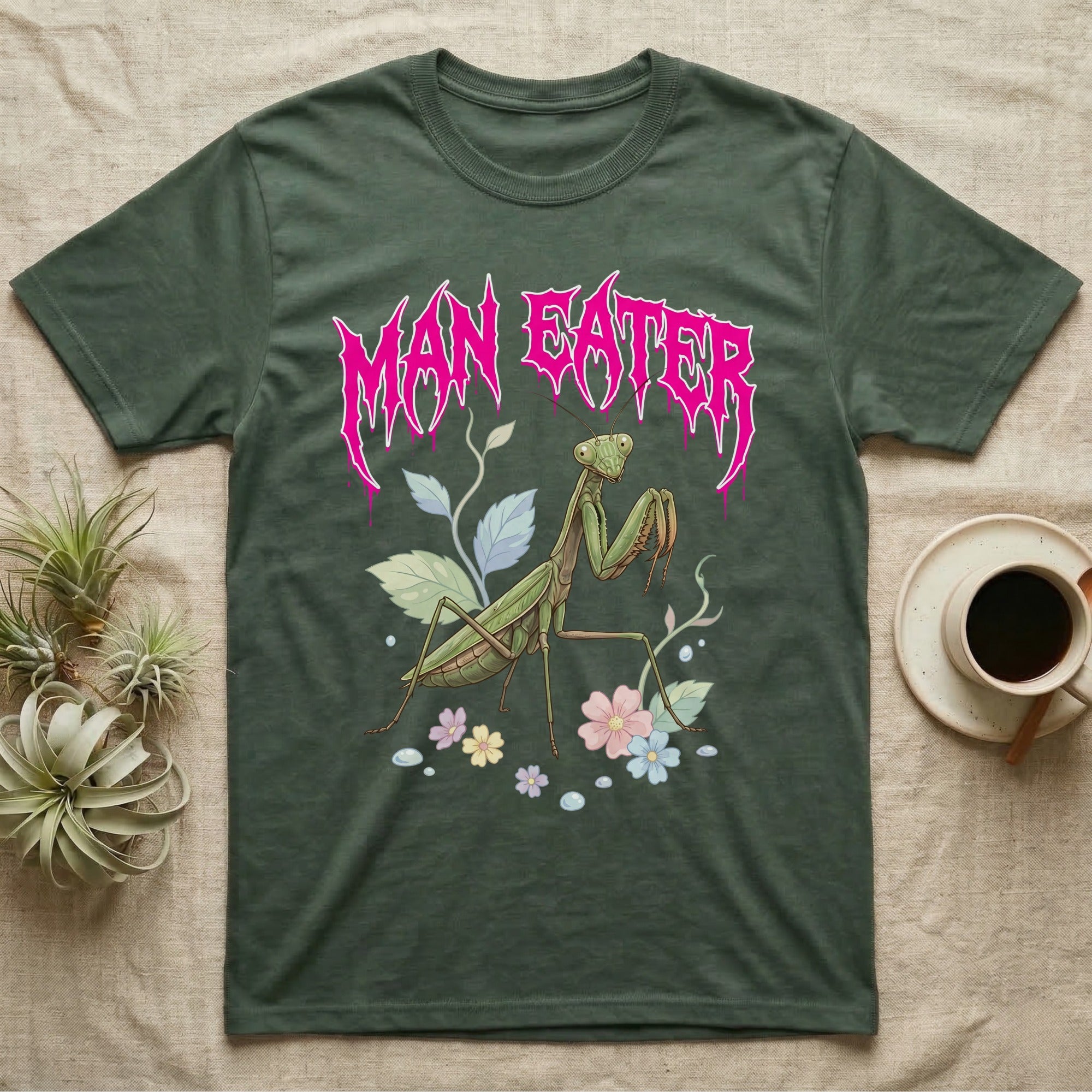 Chinese Mantis Feral T-Shirt in Military Green — Pastel Chinese mantis with raised spiked forelegs among leaves and blossoms, jagged magenta metal wordmark "MAN EATER" above.