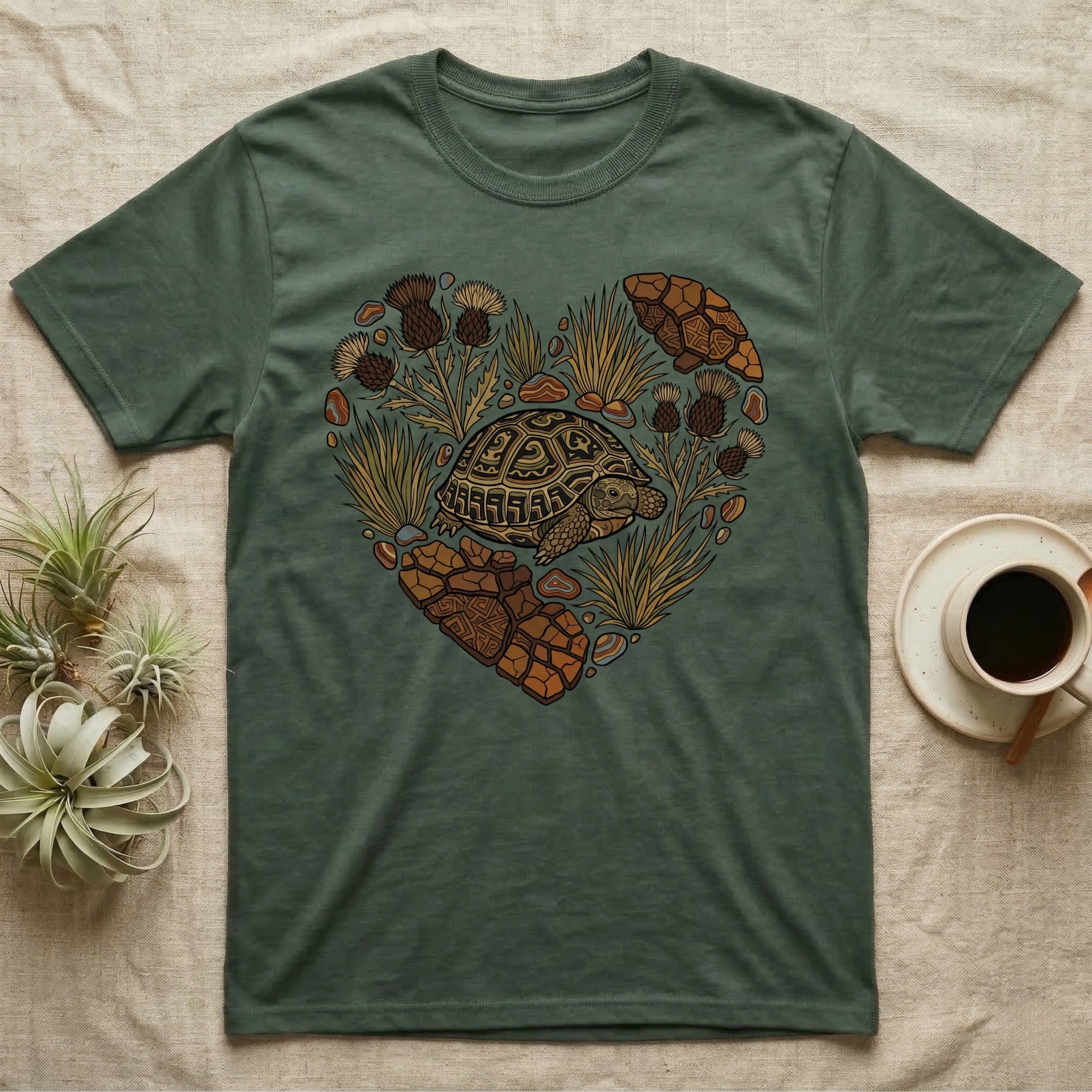 Green t-shirt with heart-shaped tortoise and desert plant graphic.