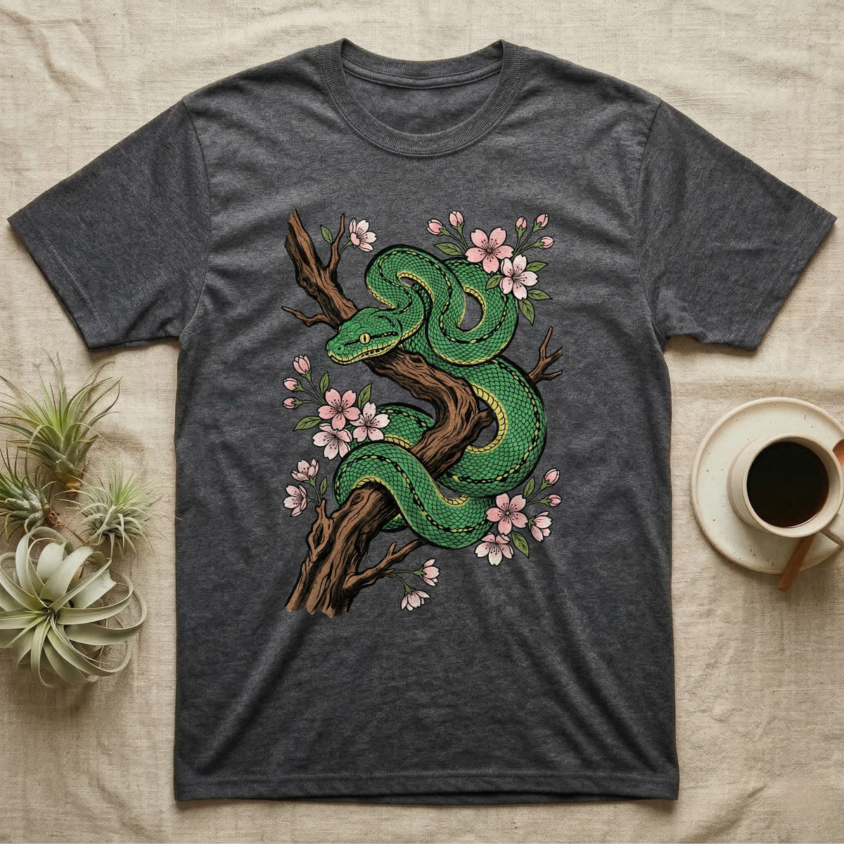 Green snake coiled on a branch with pink cherry blossoms.